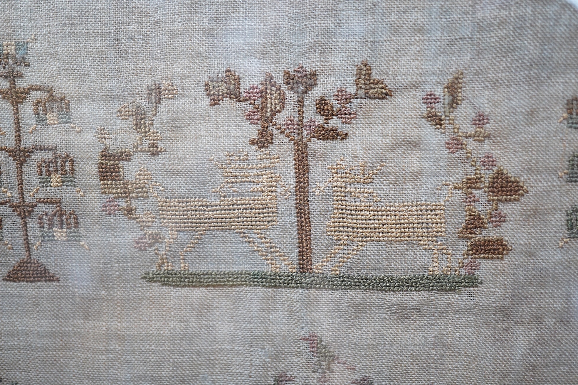 A sampler with spot motifs and central cartouche, embroidered with Ann Richardson, her work aged 14 years 1824. A very finely embroidered large spot sampler worked with motifs of stags, trees, planters of flowers with in